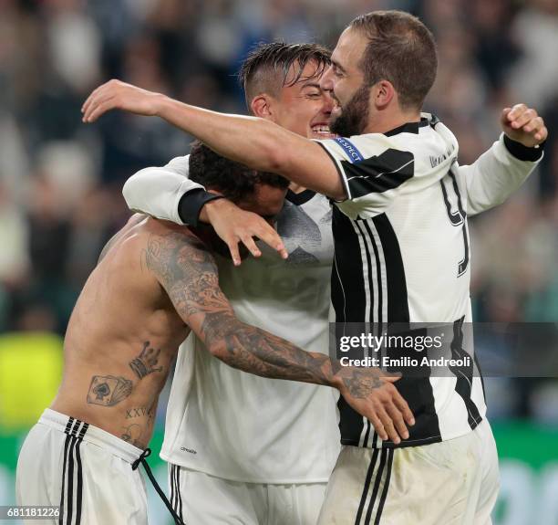 Paulo Dybala of Juventus FC celebrates with his team mates Daniel Alves da Silva and Gonzalo Higuain the victory at the end of the UEFA Champions...