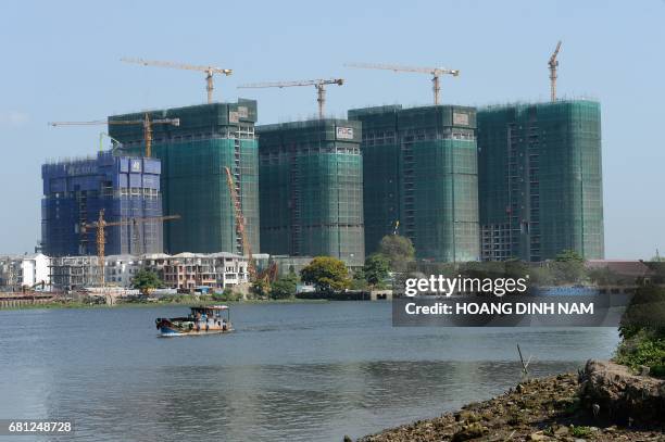 This picture taken on February 21, 2017 shows the new highrise buildings under construction on the bank of Saigon river in Ho Chi Minh City . They...