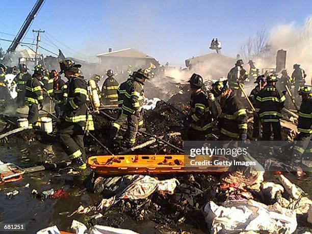 New York City firefighters remove bodies from the wreckage of American Airlines flight 587 November 12, 2001 in Rockaway Beach, Queens after the...