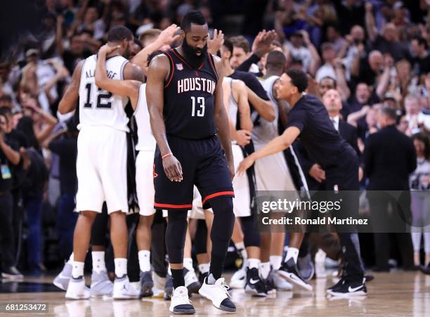 James Harden of the Houston Rockets walks off the court as the San Antonio Spurs celebrate a win in overtime during Game Five of the Western...