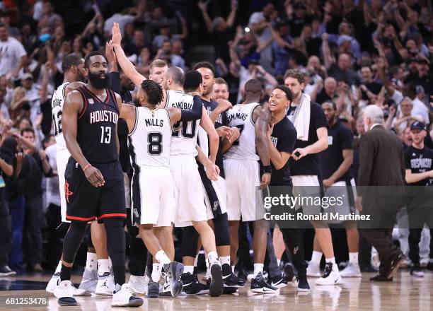 James Harden of the Houston Rockets walks off the court as the San Antonio Spurs celebrate a win in overtime during Game Five of the Western...