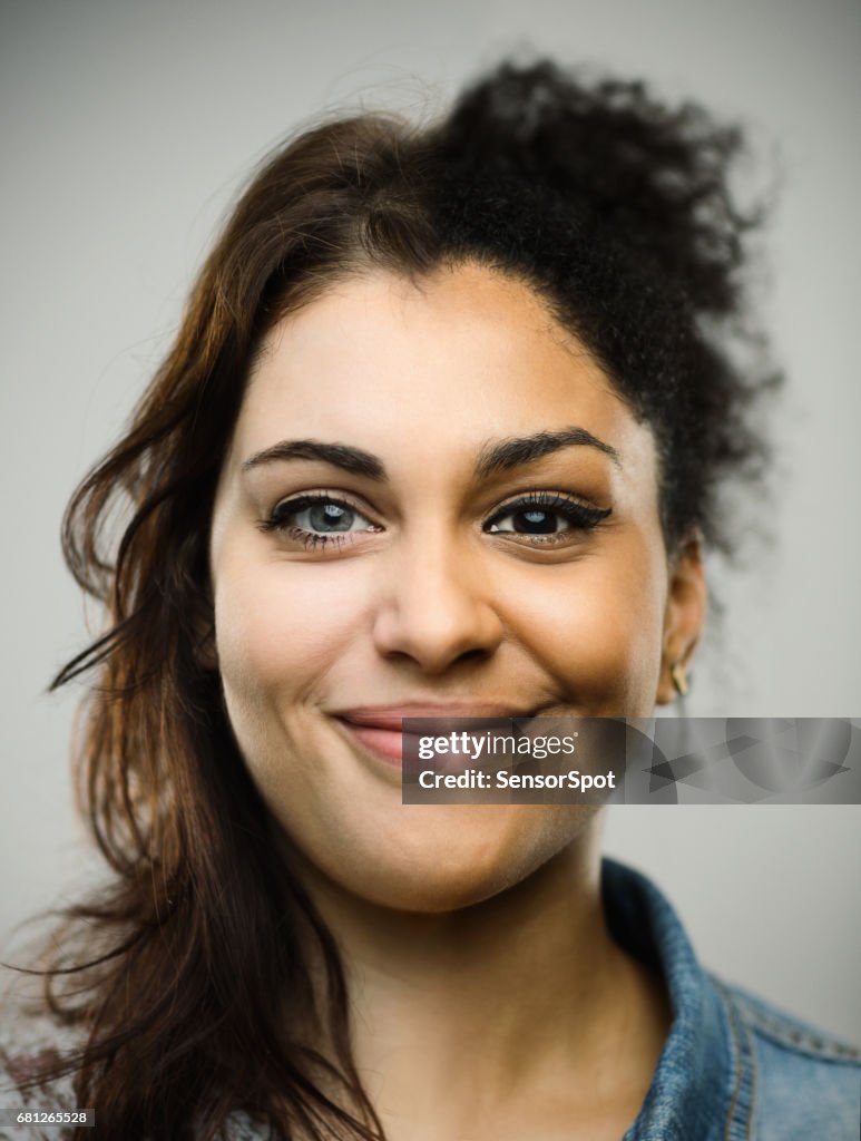 Excited woman smiling against gray background