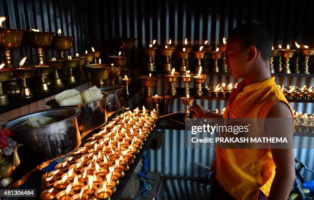 Nepalese Buddhist monk lights butter lamps during Buddha Purnima, which marks the Buddha's birthday, in Kathmandu on May 10, 2017. The Buddha was...