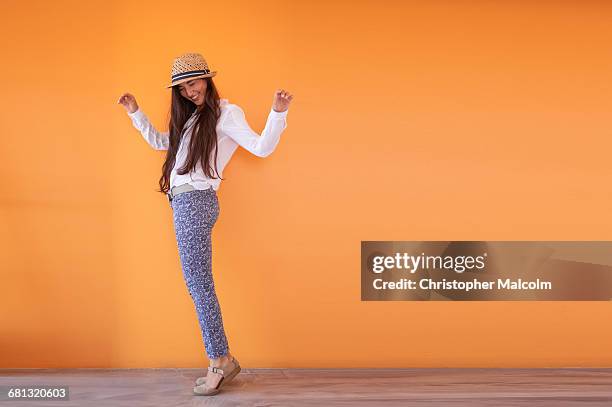 asian woman smiling in front of orange wall - happy woman arms raised stock pictures, royalty-free photos & images