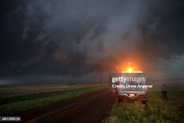 Support scientist Tim Marshall, a 40 year veteran of storm chasing, hops out of the tornado scout vehicle to observe a supercell thunderstorm as it...