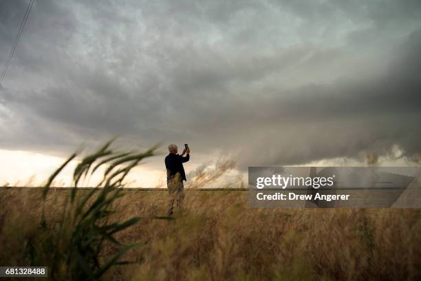 Support scientist Tim Marshall, a 40 year veteran of storm chasing, photographs supercell thunderstorm during a tornado research mission, May 9, 2017...