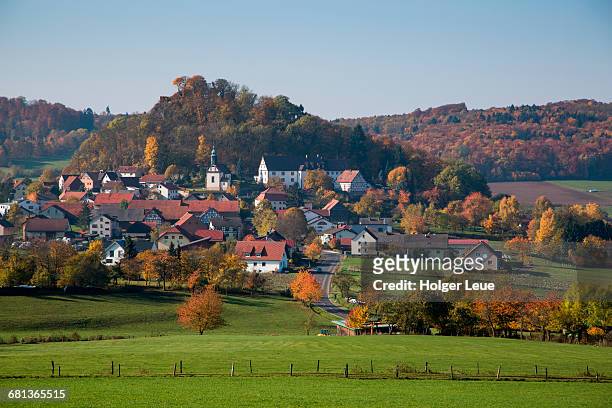 haselstein village and trees with autumn foliage - hesse germany stock-fotos und bilder