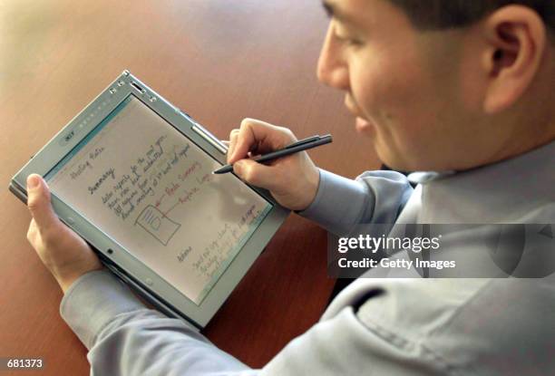 Charlton Lui , a Microsoft development manager, demonstrates an Acer tablet PC prototype November 7, 2001 in Seattle. Microsoft chairman and chief...