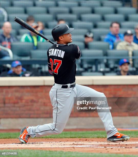 Giancarlo Stanton of the Miami Marlins follows through on his three run home run in the first inning in an MLB baseball game against the New York...