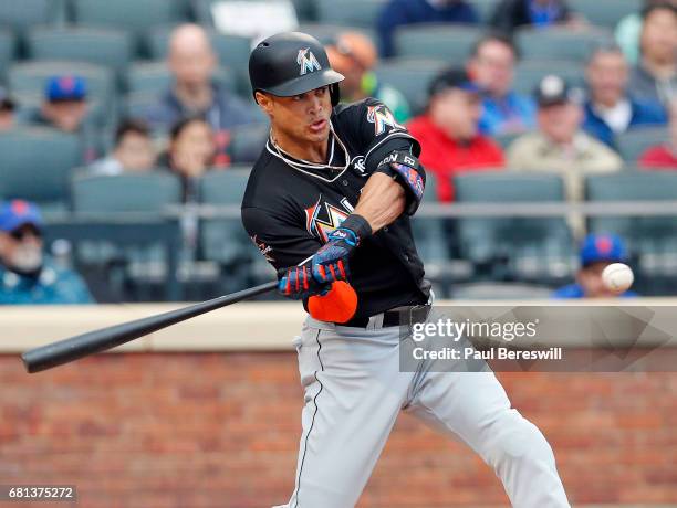 Giancarlo Stanton of the Miami Marlins drops his bat as he watches his second home run of the game head into the stands in an MLB baseball game...