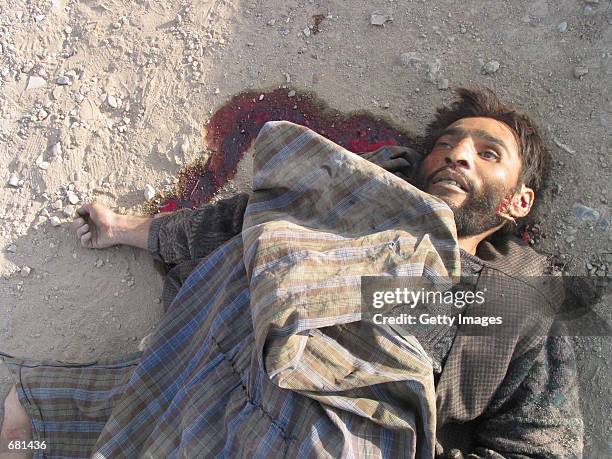 Taliban fighter lies dead by the side of the road November 12, 2001 in Kabul, Afghanistan. Opposition fighters captured Afghanistan's capital in...