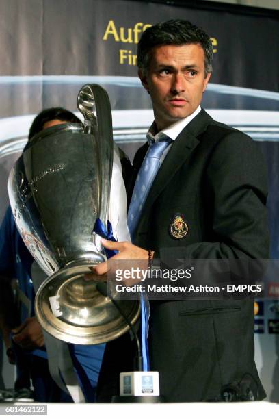 Porto's coach Jose Mourinho walks of with with the UEFA Champions League trophy after the press conference after his sides win against Monaco