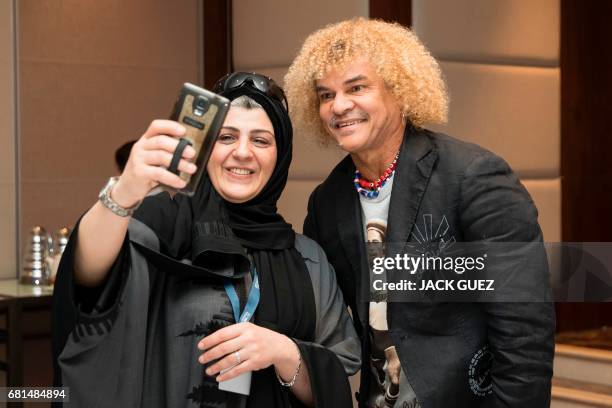 Retired Colombian football player Carlos Valderrama poses for a selfie photograph during a Q&A session before a game of FIFA Legends in the Bahraini...