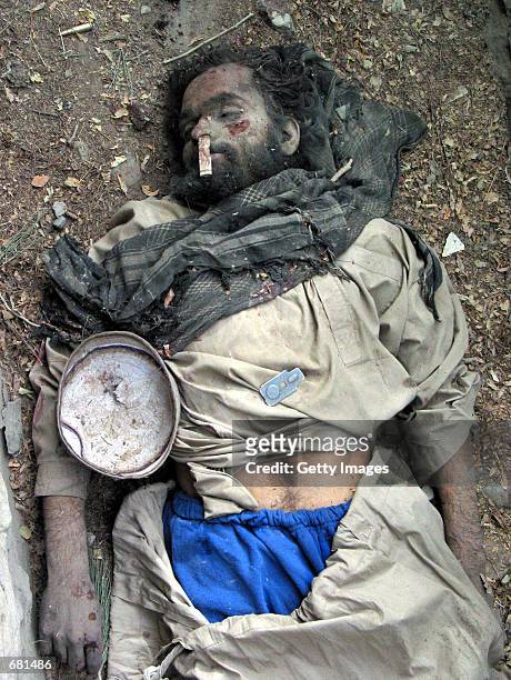 Pro-Taliban foreign fighter lies dead in a ditch November 13, 2001 in a central city park in Kabul, Afghanistan. Money has been stuffed up the dead...