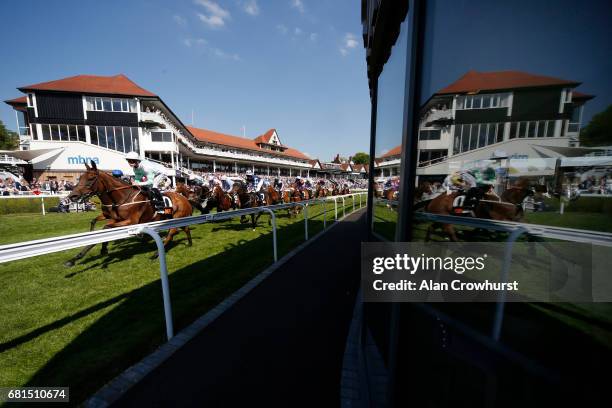 Runners in The 188Bet Chester Cup Handicap Stakes make a reflection in a restaurant window as they pass the grandstands at Chester Racecourse on May...