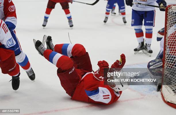 Russian President Vladimir Putin falls down during the 'Night League' teams ice hockey Gala match at the Shayba Olympic Arena in Sochi on May 10,...