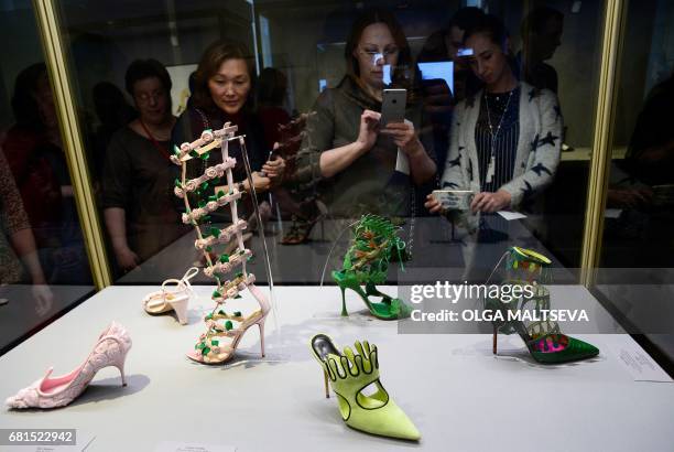 Visitors look at creations by Spanish fashion designer and founder of the eponymous high-end shoe brand Manolo Blahnik during the exhibition "The Art...