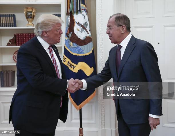 President Donald Trump and Russia's Foreign Minister Sergei Lavrov shake hands as they meet at the Oval Office of White House in Washington, D.C.,...