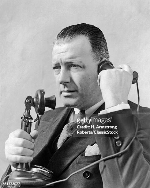 1920s MAN TALKING ON CANDLESTICK TELEPHONE