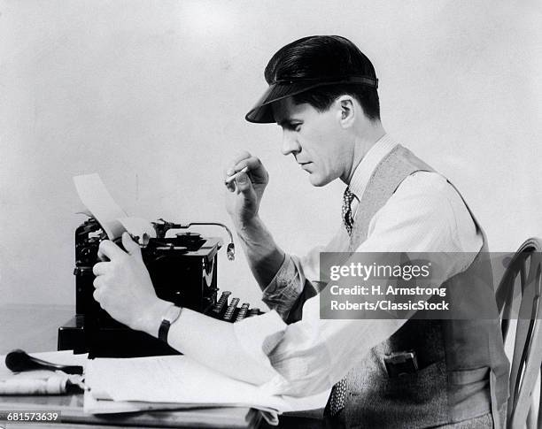 1930s MAN AT THE TYPEWRITER WEARING A VISOR SHIRT TIE AND VEST SMOKING A CIGARETTE WHILE TAKING PAPER FROM THE TYPEWRITER