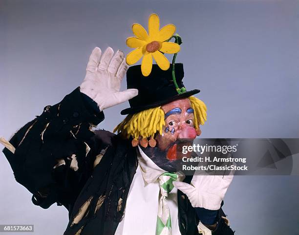 1960s HOBO STYLE CLOWN WEARING TOP HAT WITH DAISY PERFORMING LOOKING AT CAMERA