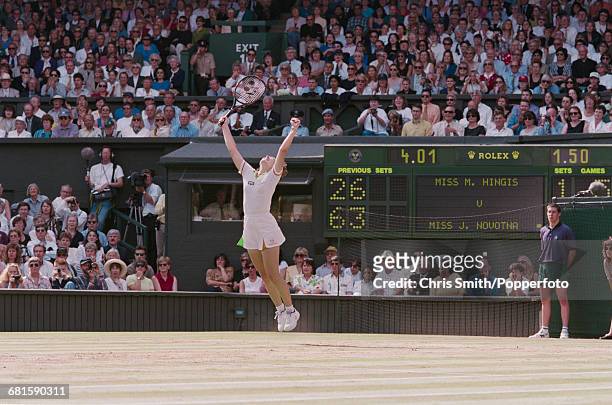 Swiss tennis player Martina Hingis leaps and throws her arms in the air in celebration after beating Czech tennis player Jana Novotna, 2-6, 6-3, 6-3...