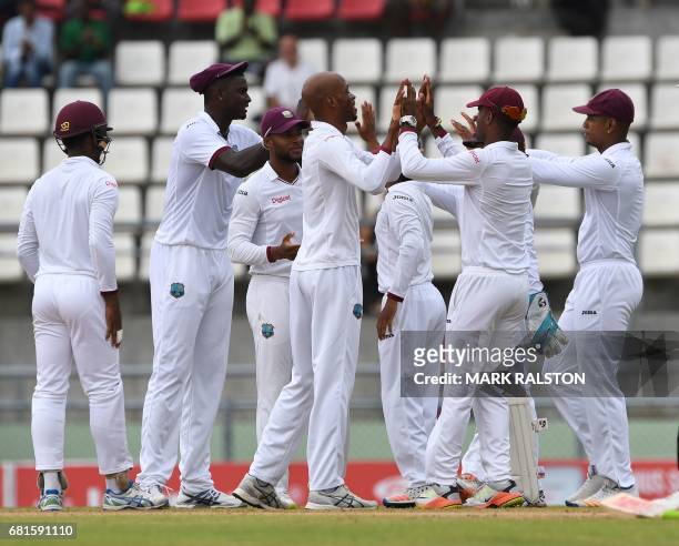 West Indies bowler Roston Chase celebrates with teammates after taking the wicket of Shan Masood of Pakistan on the first day of play, during the 3rd...