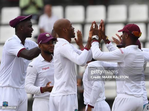 West Indies bowler Roston Chase celebrates with teammates after taking the wicket of Shan Masood of Pakistan on the first day of play, during the 3rd...