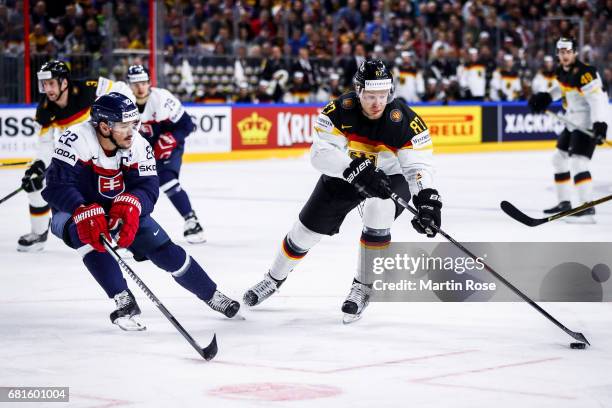Vladimir Dravecky of Slovakia challenges Philip Gogulla of Germany for the puck during the 2017 IIHF Ice Hockey World Championship game between...