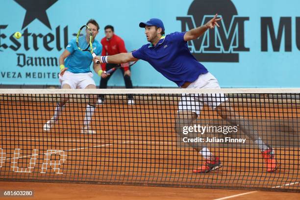 Fabrice Martin of France plays a volley with partner Daniel Nestor of Canada in the doubles against Bob and Mike Bryan of USA during day five of the...