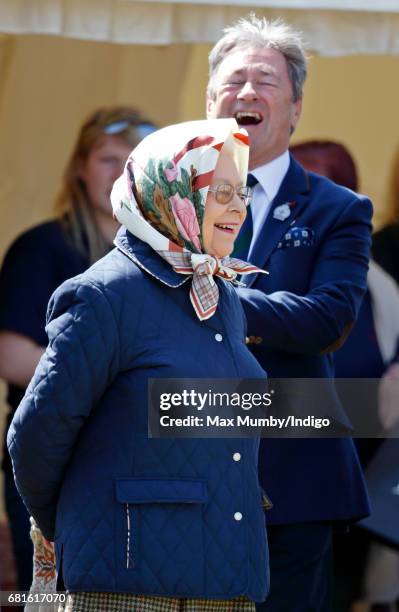 Queen Elizabeth II, accompanied by Alan Titchmarsh, watches her horse 'Tower Bridge' compete in The Cuddy Heavyweight Hunter Class on day 1 of the...
