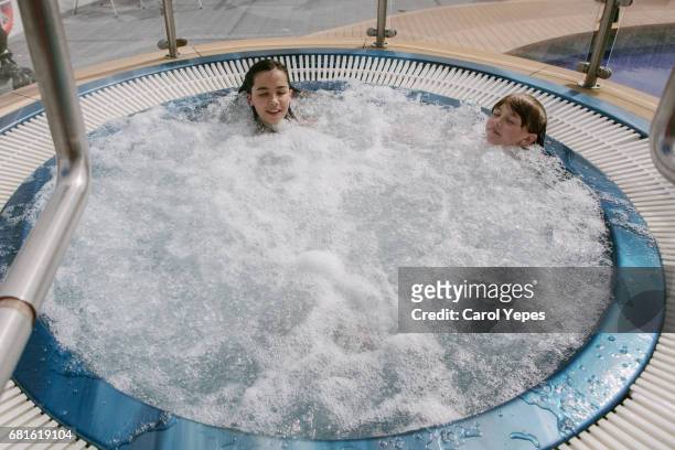 two kids enjoying hot tube during holidays - girls in hot tub stockfoto's en -beelden