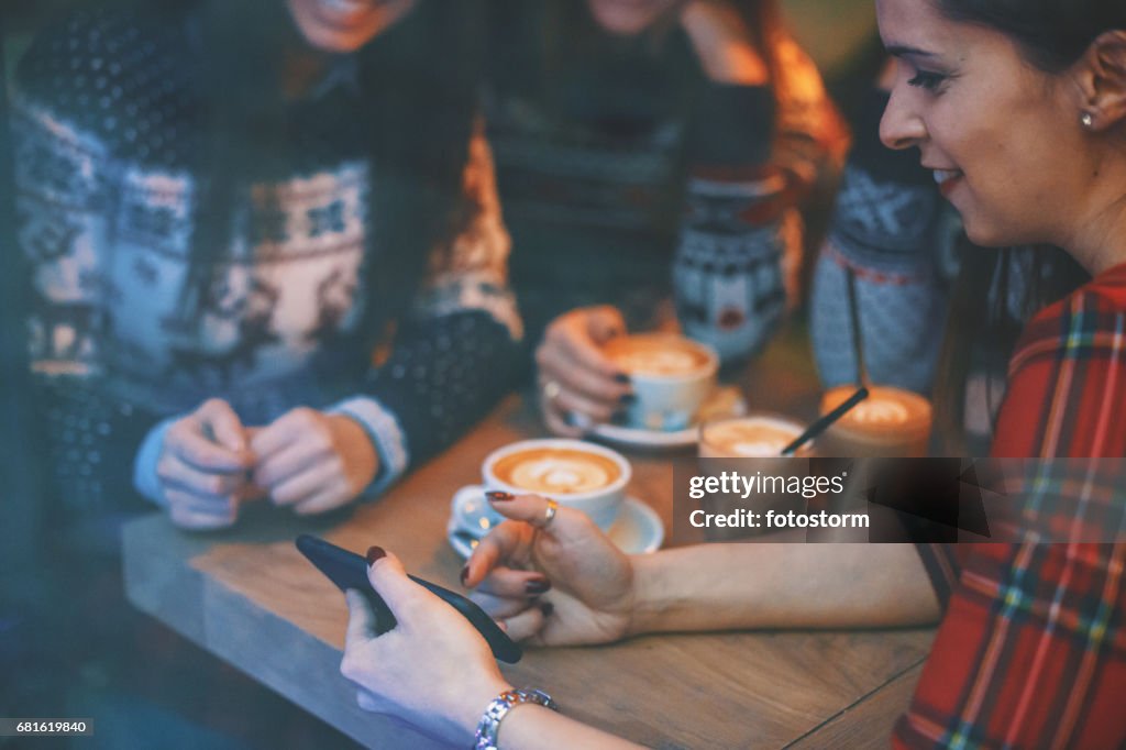 スマート フォンを見下ろすカフェで友人