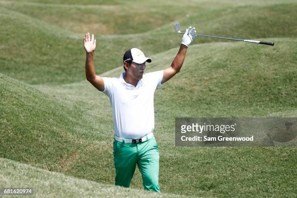 Sung Kang of South Korea reacts to chipping in during a practice round prior to THE PLAYERS Championship at the Stadium course at TPC Sawgrass on May...
