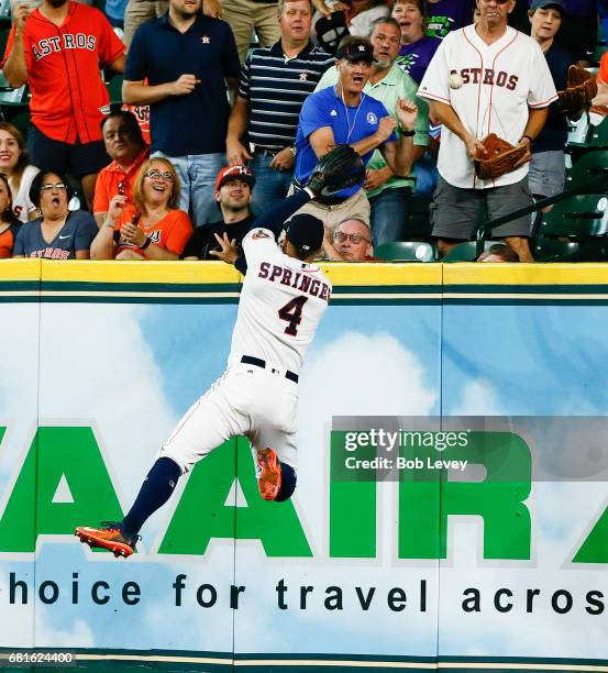 Houston Astros center fielder George Springer leaps at the wall but unable to catch a home run by Atlanta Braves third baseman Adonis Garcia in the...