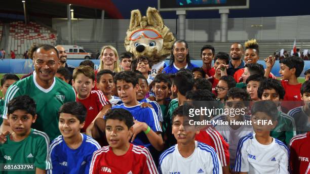 Legends Cafu, Nia Kuenzer, Ronaldinho and Karina LeBlanc find themselves swamped by local children during a grassroots training sesson at the Bahrain...