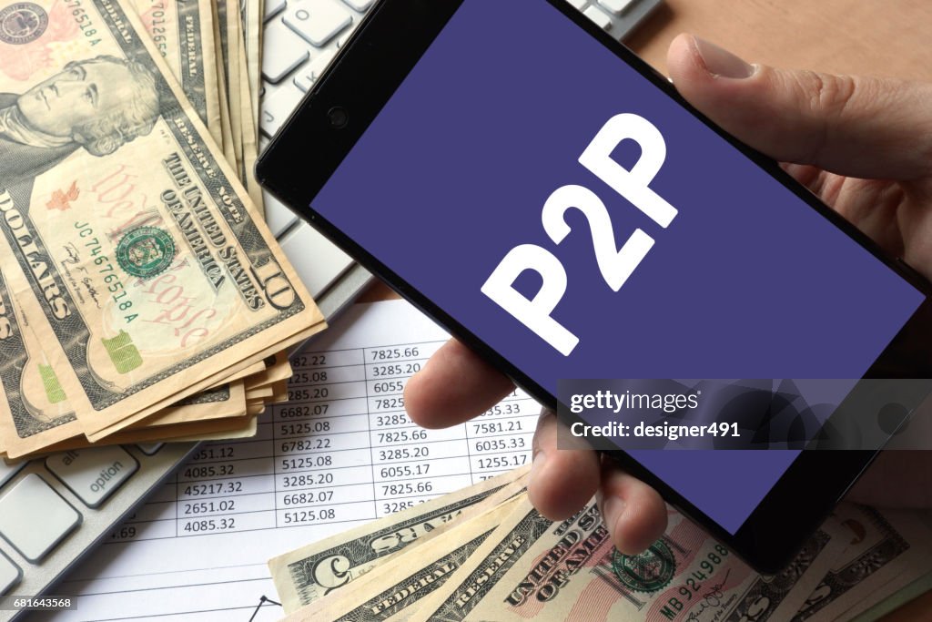 Smartphone in hand with P2P. Peer to peer lending concept.