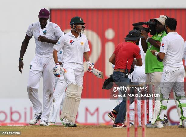 West Indies players led by captain Jason Holder form a guard of honour for batsman Younis Khan of Pakistan who is playing in his final test match,...