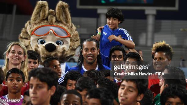 Legends Nia Kuenzer, Ronaldinho and Karina LeBlanc find themselves surrounded by local children during a grassroots training sesson at the Bahrain...