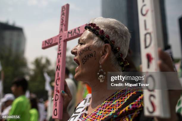 Demonstrator holds up wooden crosses during a march on Mother's Day on May 10, 2017 in Mexico City, Mexico. Mothers whose children are missing during...