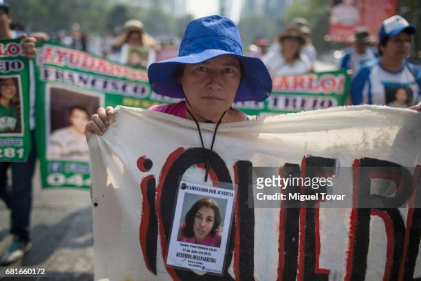 Mother of a disappeared holds up signs with images of her missing relative during a march on Mother's Day on May 10, 2017 in Mexico City, Mexico....