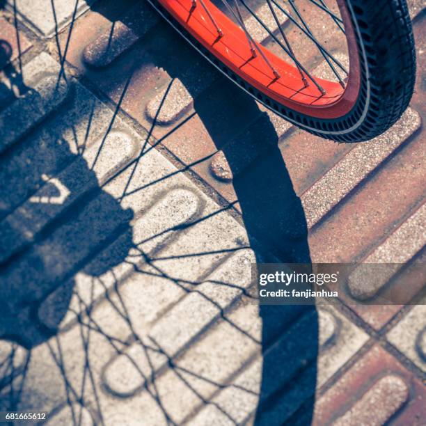 closeup of bicycle parked on sidewalk - motorcycle tyre stockfoto's en -beelden