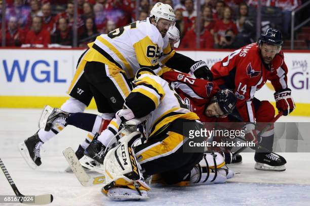 Ron Hainsey and Marc-Andre Fleury of the Pittsburgh Penguins go after the puck against Evgeny Kuznetsov and Justin Williams of the Washington...