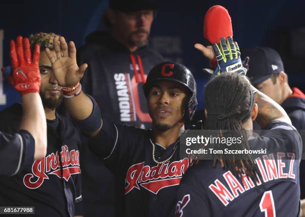 Francisco Lindor of the Cleveland Indians is congratulated by teammates in the dugout after scoring a run in the third inning during MLB game action...