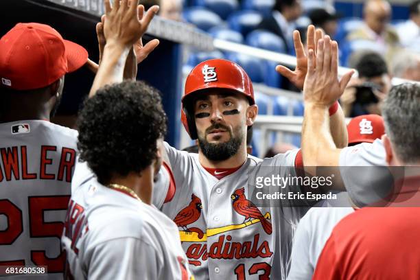 Matt Carpenter of the St. Louis Cardinals is congratulated by teammates after scoring in the third inning against the Miami Marlinsat Marlins Park on...
