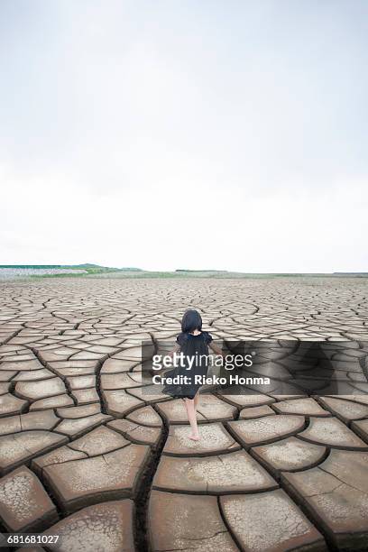 little girl walking on the dry land - paisaje árido fotografías e imágenes de stock