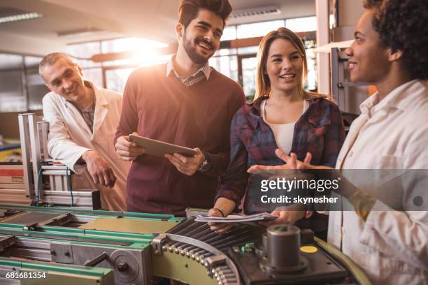 young happy students talking to engineers in a manufacturing factory. - engeneer student electronics stock pictures, royalty-free photos & images