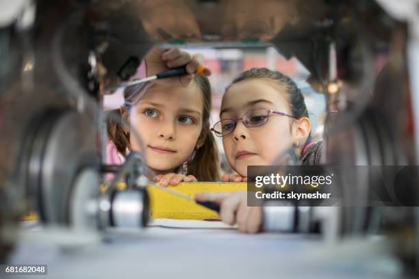 twee kleine ingenieurs werken in team bij het herstellen van een robot. - child with robot stockfoto's en -beelden