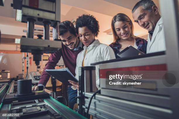team of happy engineers analyzing data of a manufacturing machine. - engeneer student electronics stock pictures, royalty-free photos & images
