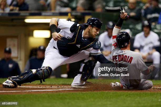 Jett Bandy of the Milwaukee Brewers tags out Dustin Pedroia of the Boston Red Sox at home plate in the first inning at Miller Park on May 10, 2017 in...